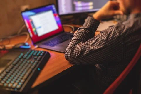 IT developer programmer working and coding on his worplace at home, laptop an Stock Photos