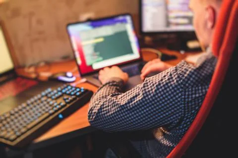 IT developer programmer working and coding on his worplace at home, laptop an 库存照片