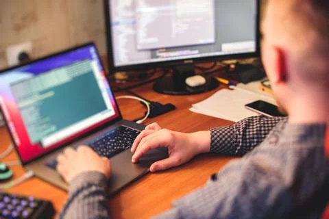 IT developer programmer working and coding on his worplace at home, laptop an Stock Photos
