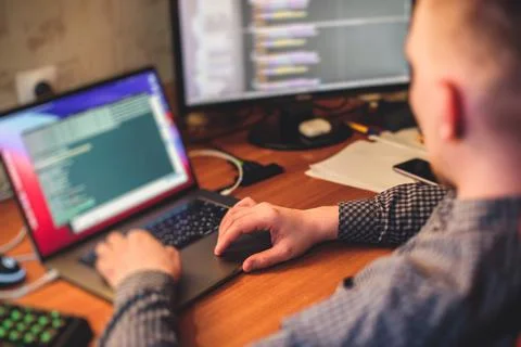 IT developer programmer working and coding on his worplace at home, laptop an Foto stock
