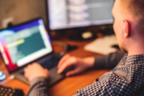 IT developer programmer working and coding on his worplace at home, laptop an 库存照片