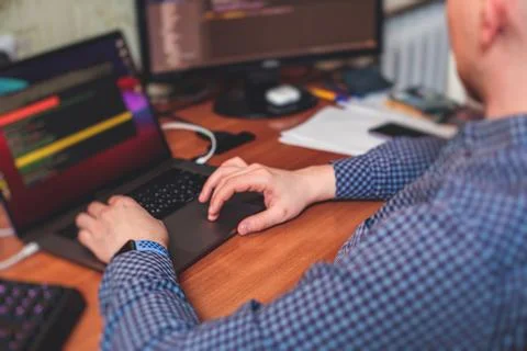 IT developer programmer working and coding on his worplace at home, laptop an Stockfoto's