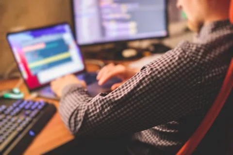 IT developer programmer working and coding on his worplace at home, laptop an 库存照片