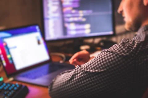 IT developer programmer working and coding on his worplace at home, laptop an Stockfoto's