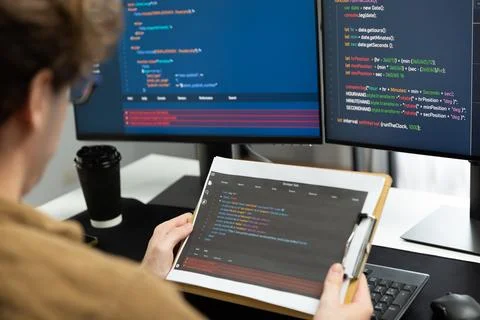 IT developer reading coding on document paper software with screens. Gusher. Foto stock