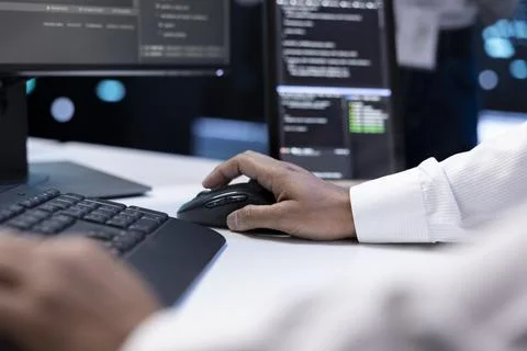 IT developer working on computer in server farm housing data management rigs Stockfoto's