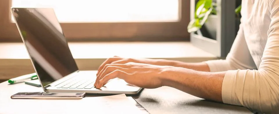 IT developer working on laptop in cafe, typing on keyboard Stock Photos