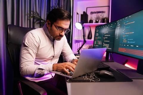 IT developer working laptop to search code system at neon light office. Surmise. Stock Photos