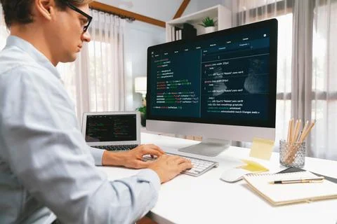 IT developer working online software development on pc and laptop. Pecuniary. Stock Photos