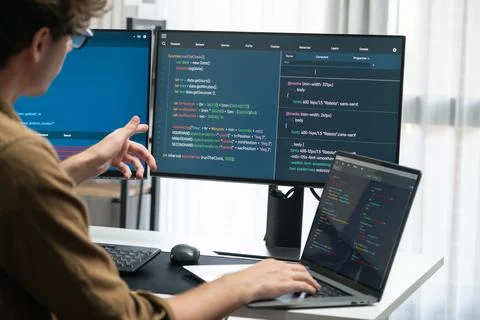IT developer working online software development coding on pc screens. Gusher. Stock Photos