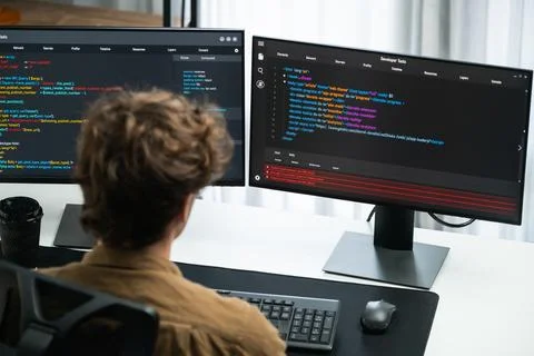 IT developer working online software development coding on pc screens. Gusher. Stock Photos