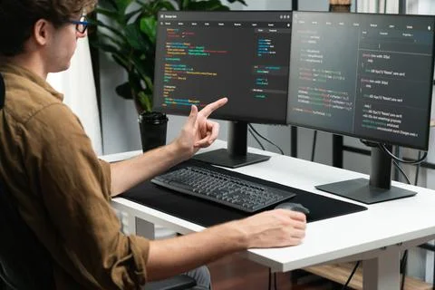 IT developer working online software development coding on pc screens. Gusher. Stock Photos