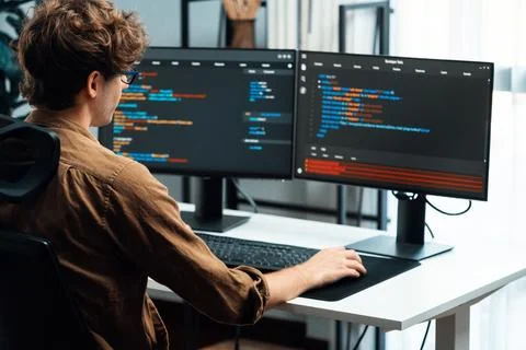 IT developer working online software development coding on pc screens. Gusher. Stock Photos