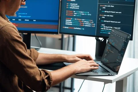 IT developer working online software development coding on pc screens. Gusher. Foto stock