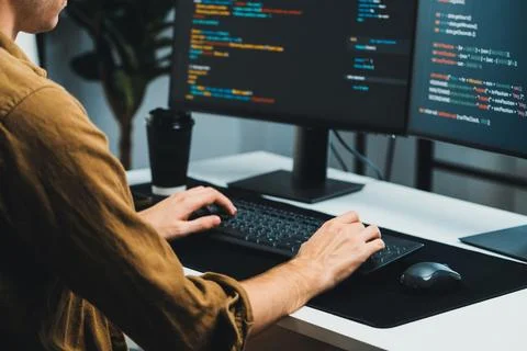 IT developer working online software development coding on pc screens. Gusher. Stock Photos