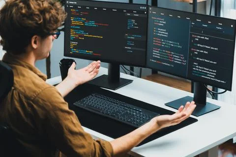 IT developer working online software development coding on pc screens. Gusher. Stock Photos