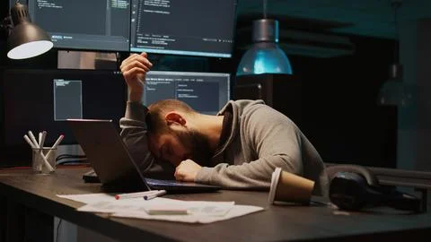IT developer yawning and falling asleep on desk Foto stock
