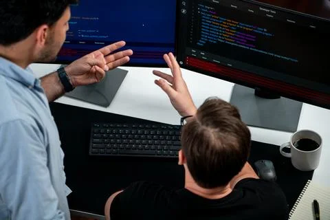 IT developers discussing online software development information. Sellable. Stock Photos