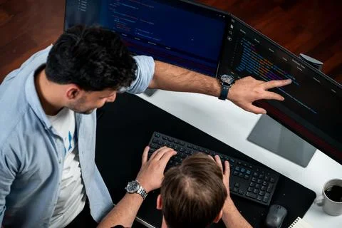 IT developers discussing online software development information. Sellable. 库存照片