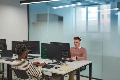 IT Developers Working at Computer Desks in Office Stock Photos