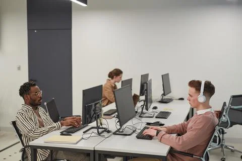 IT Developers Working at Desks in Office Side View Stock Photos