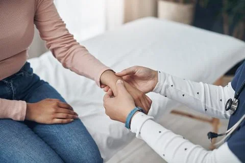 It does feel a bit sensitive. a unrecognizable doctor checking a patients wrist Stock Photos