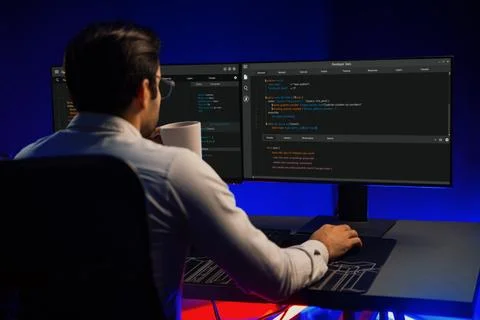 IT drinking coffee cup while working at back side view at neon office. Surmise. 写真素材