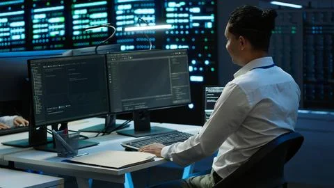 IT employee at work doing maintenance on server room hardware 写真素材