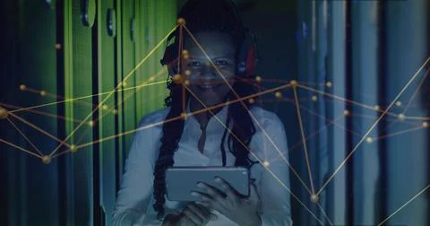 IT engineer analyzing network graph in LED-lit server rack aisle, with tablet, Stock Photos