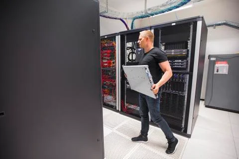 IT Engineer Carrying Blade Server While Walking In Datacenter Stock Photos