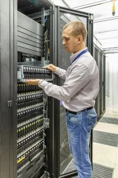 IT Engineer installs JBOD  to rack in datacenter Stock Photos