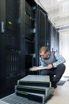 IT Engineer installs JBOD to rack in datacenter Stock Photos