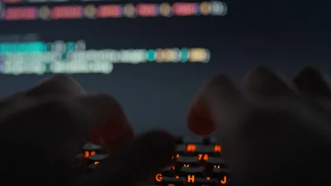 An IT engineer intensely types complex code on the keyboard fine-tuning a so Stock Footage 331315638