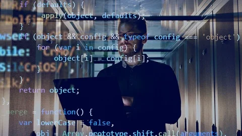 IT engineer is operating a laptop with encrypted code going above him Stock Footage 114740108