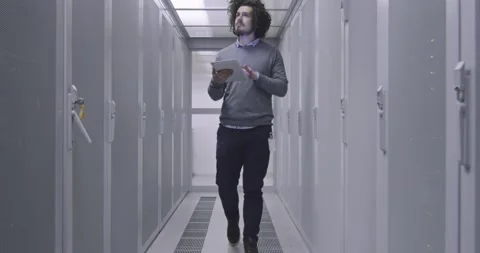 IT engineer or data science specialist working on tablet computer in server room Vídeos de archivo 219481425