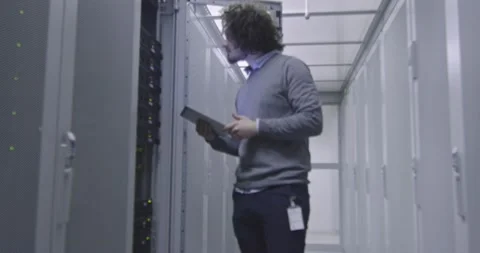 IT engineer or data science specialist working on tablet computer in server room Vídeos de archivo 219481546