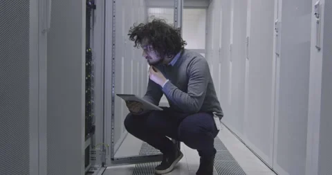 IT engineer or data science specialist working on tablet computer in server room Vídeos de archivo 219481617