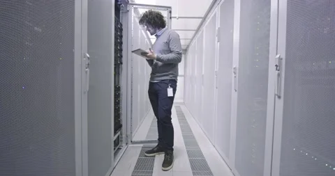 IT engineer or data science specialist working on tablet computer in server room Vídeos de archivo 219482735