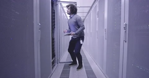 IT engineer or data science specialist working on tablet computer in server room Vídeos de archivo 219485407