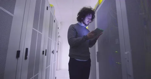 IT engineer or data science specialist working on tablet computer in server room Vídeos de archivo 219486357