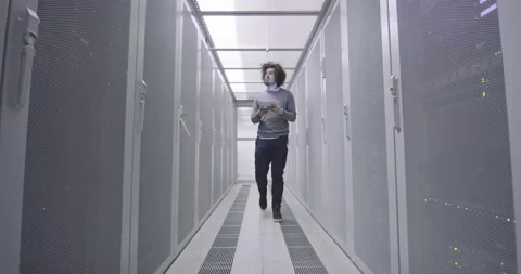IT engineer or data science specialist working on tablet computer in server room Vídeos de archivo 219486956