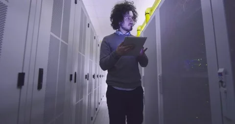 IT engineer or data science specialist working on tablet computer in server room Vídeos de archivo 219487604