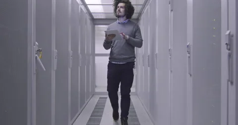 IT engineer or data science specialist working on tablet computer in server room Vídeos de archivo 219541809
