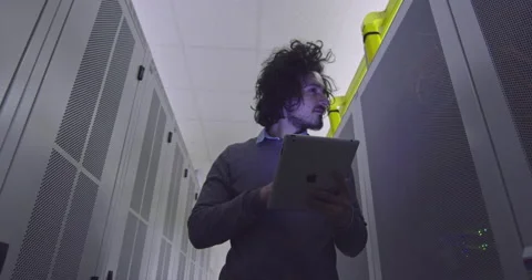 IT engineer or data science specialist working on tablet computer in server room Vídeos de archivo 219542058