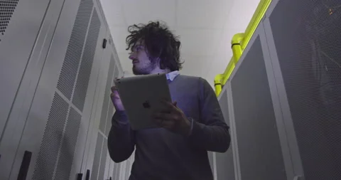 IT engineer or data science specialist working on tablet computer in server room Vídeos de archivo 219542122