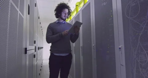 IT engineer or data science specialist working on tablet computer in server room Vídeos de archivo 219542761