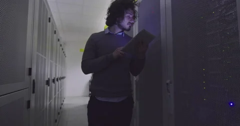 IT engineer or data science specialist working on tablet computer in server room Vídeos de archivo 219543123