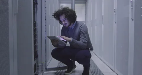 IT engineer or data science specialist working on tablet computer in server room Vídeos de archivo 219543453