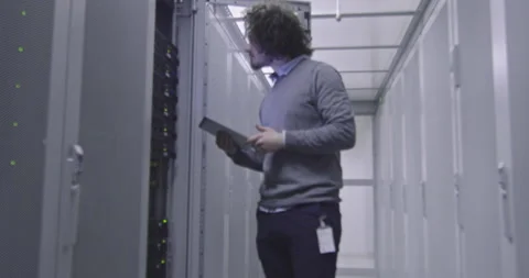 IT engineer or data science specialist working on tablet computer in server room Vídeos de archivo 219543511