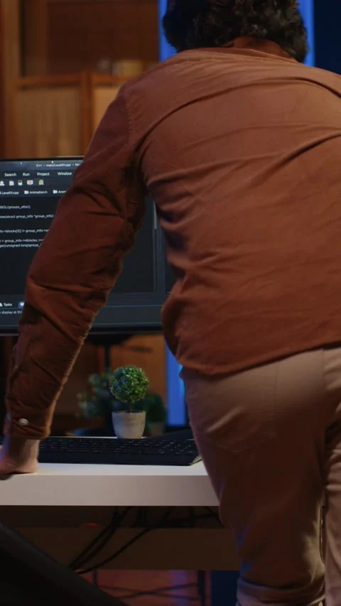 IT engineer starting job shift in apartment, writing lines of code on computer Stock Footage 264510110